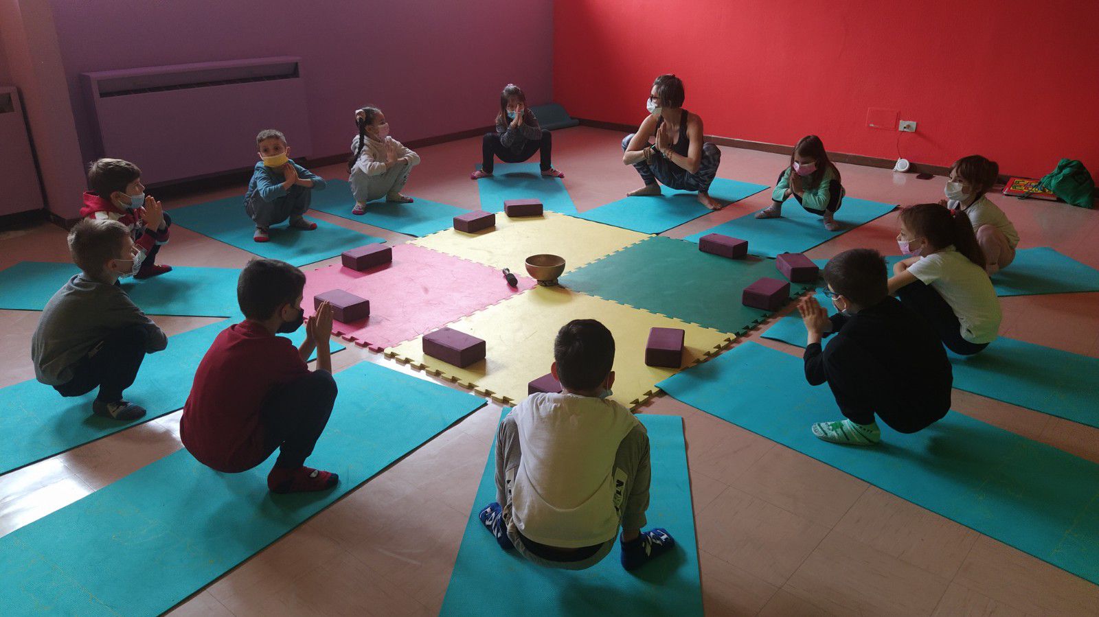 Alunni di prima impegnati in esercizi di yoga nell'aula di psicomotricità