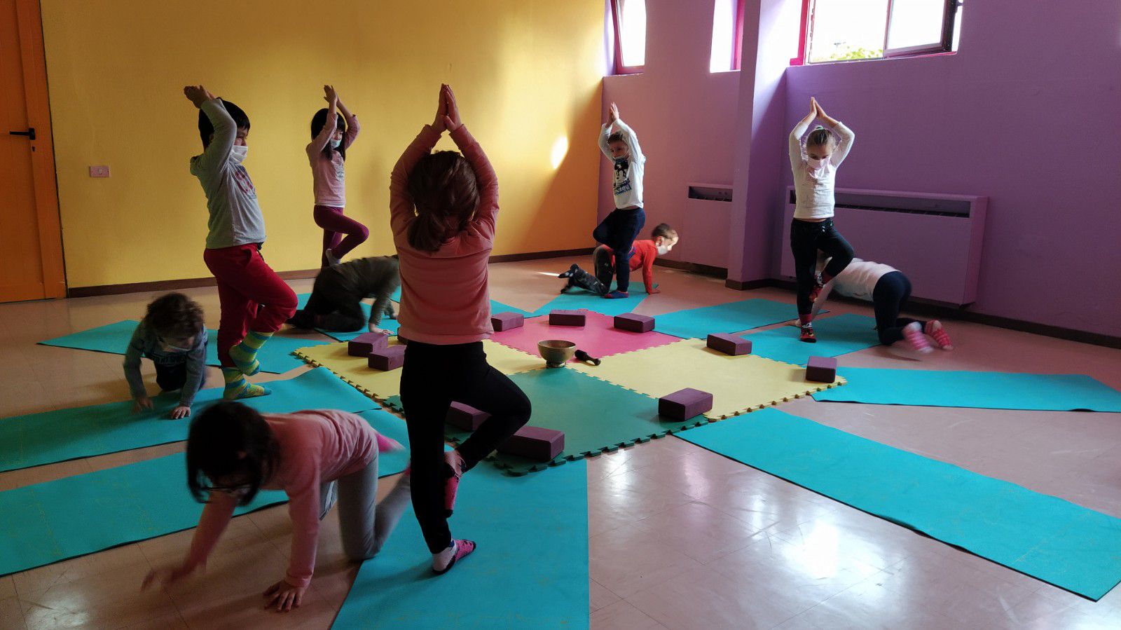 Alunni di prima impegnati in esercizi di yoga nell'aula di psicomotricità
