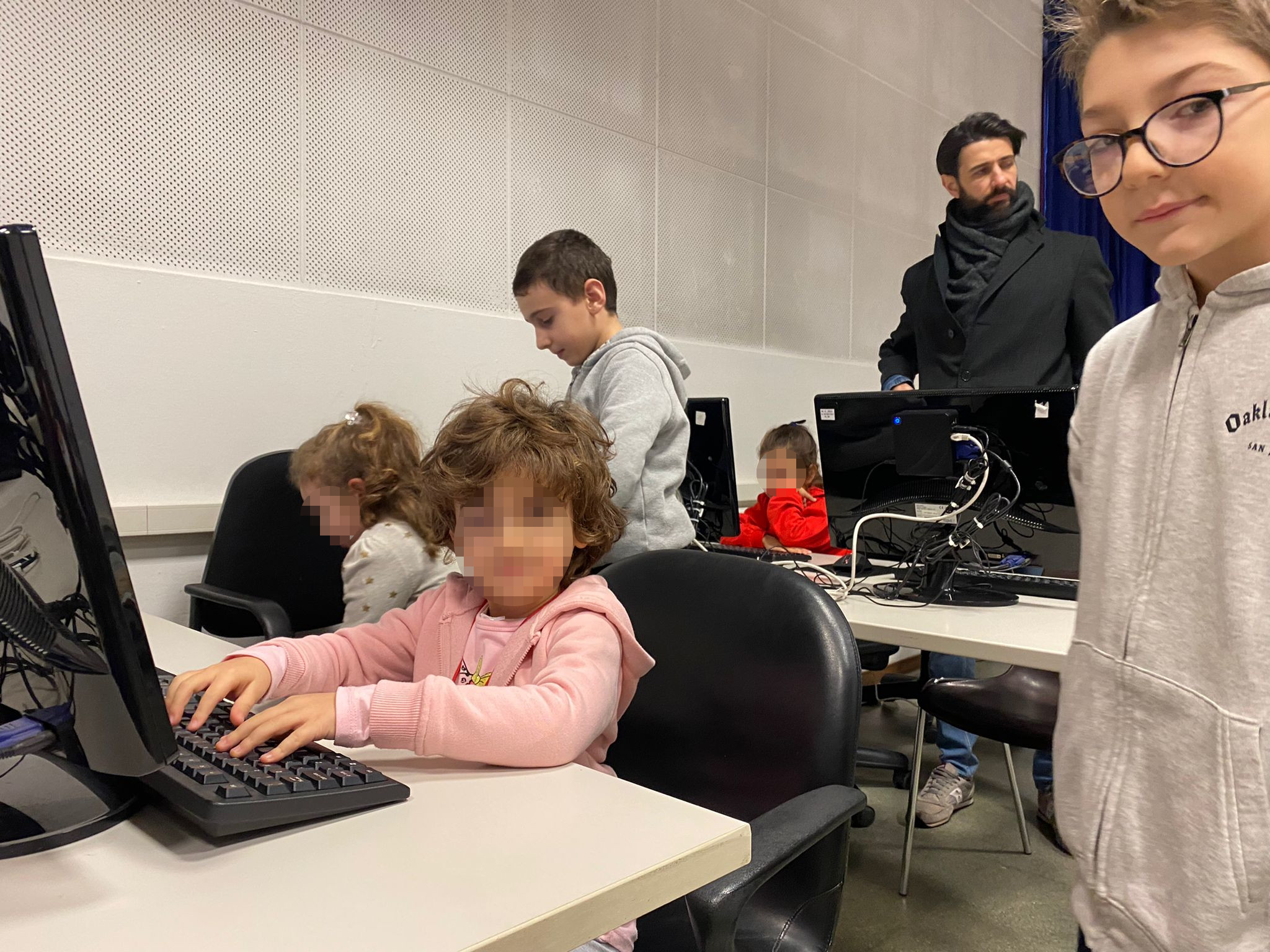 Un alunno di quinta affianca una bambina della Scuola dell'Infanzia nel laboratorio di informatica