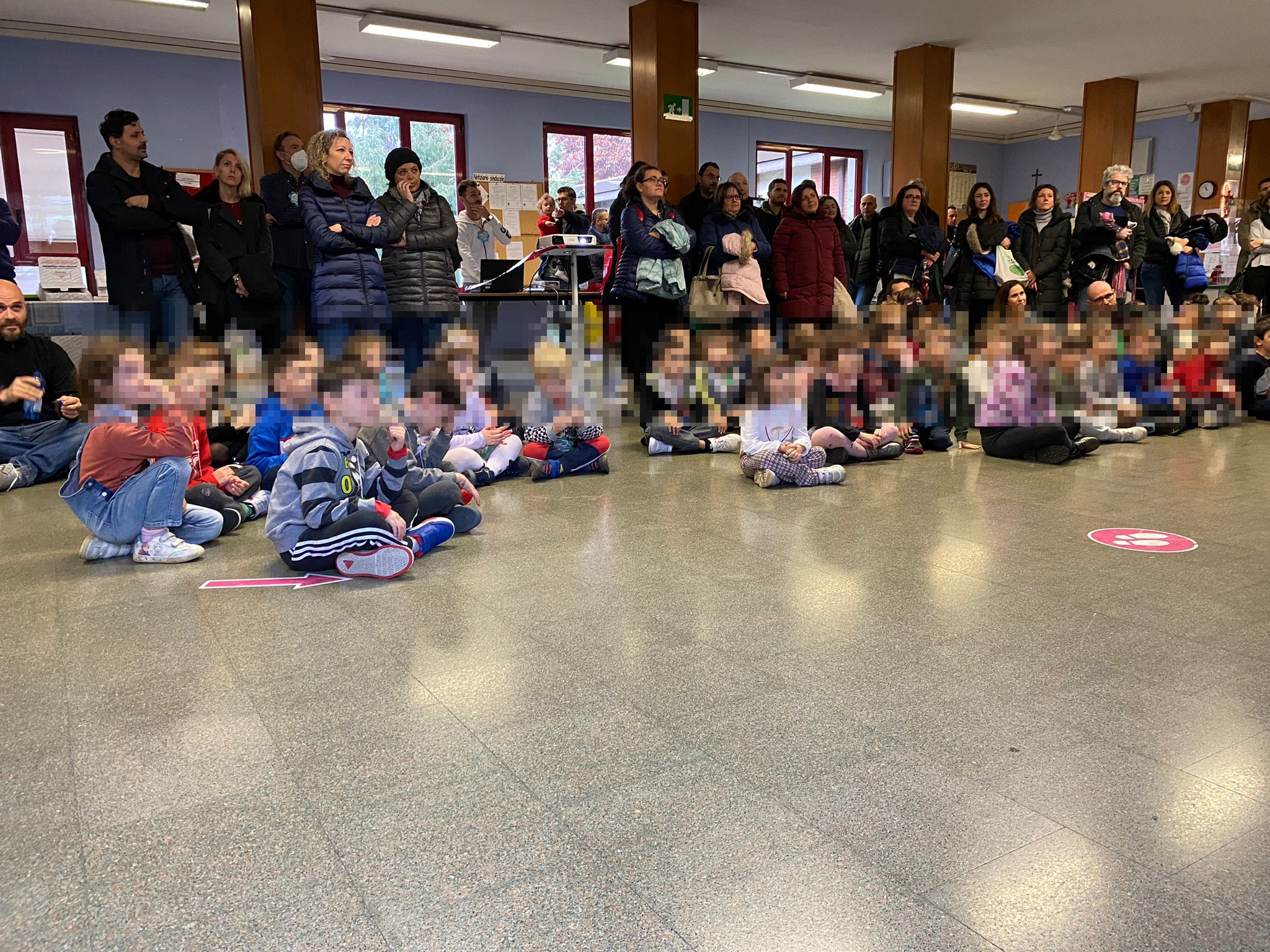 Bambini della Scuola dell'Infanzia accompagnati dai genitori sono accolti nell'atrio della Scuola Primaria Rosmini